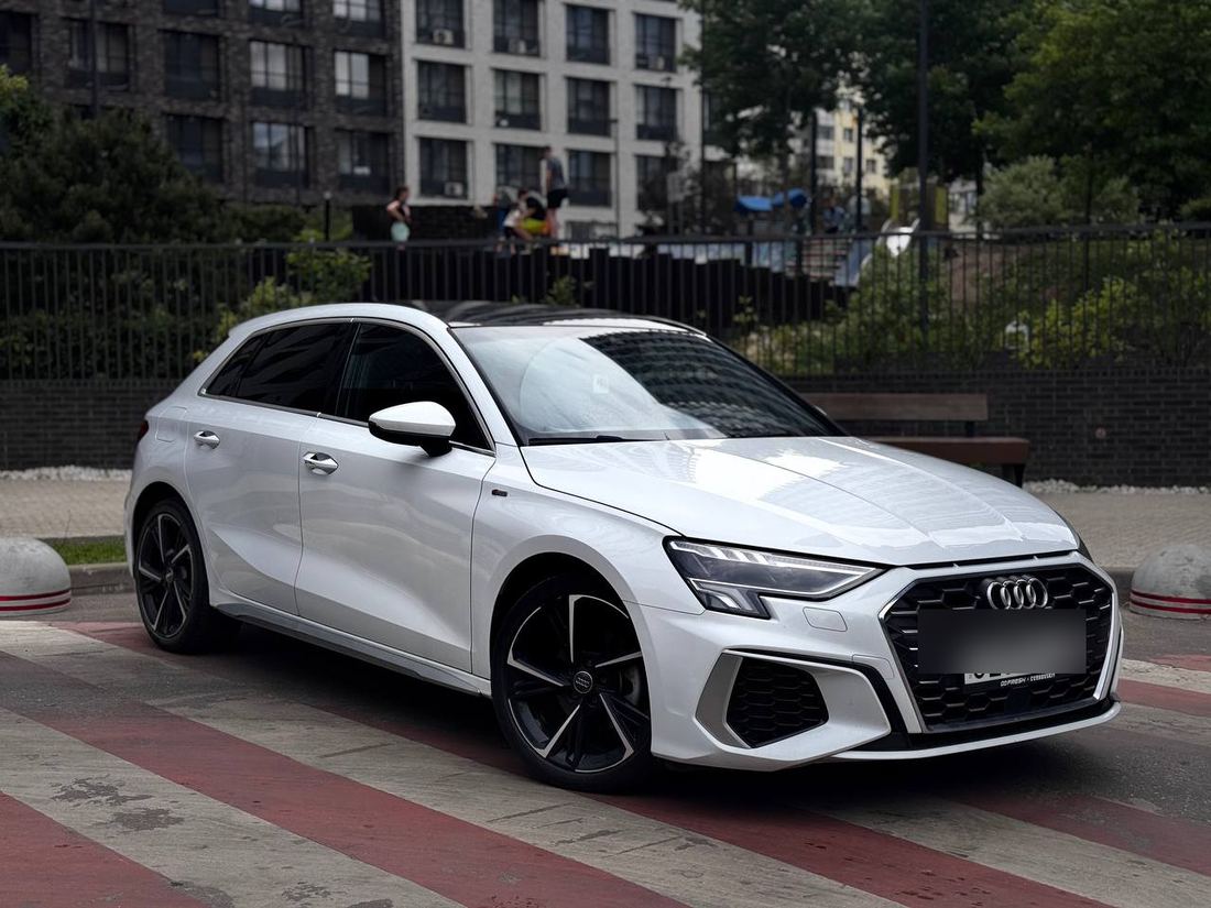 Белый Audi A3 Sportback 2023 года, вид спереди сбоку, чёрные диски S line