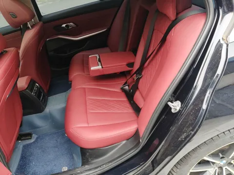 BMW G28 — задний диван с красной кожей через открытую дверь