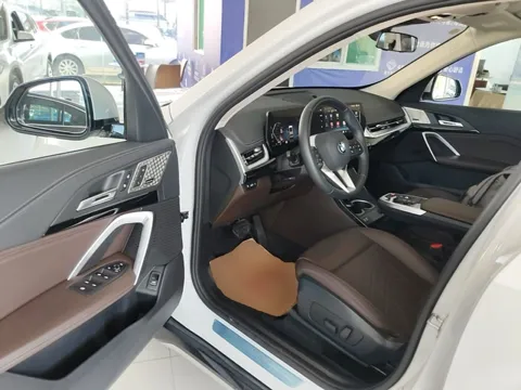 BMW X1 — водительское место через открытую дверь, коричневая кожа