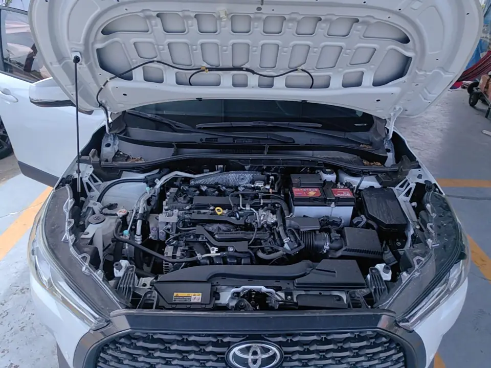 Моторный отсек белой Toyota Corolla Cross из Китая с открытым капотом