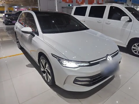 Volkswagen Golf 8 после рестайлинга, белый, вид спереди справа — светящийся логотип на решётке